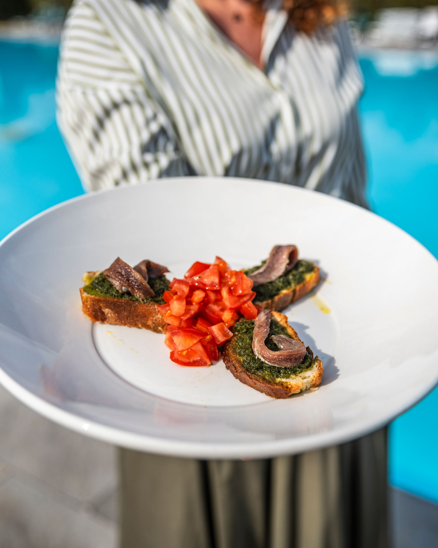 Immagine che mostra un piatto di bruschette di mare servite al pool bar di Villa Sant'Uberto